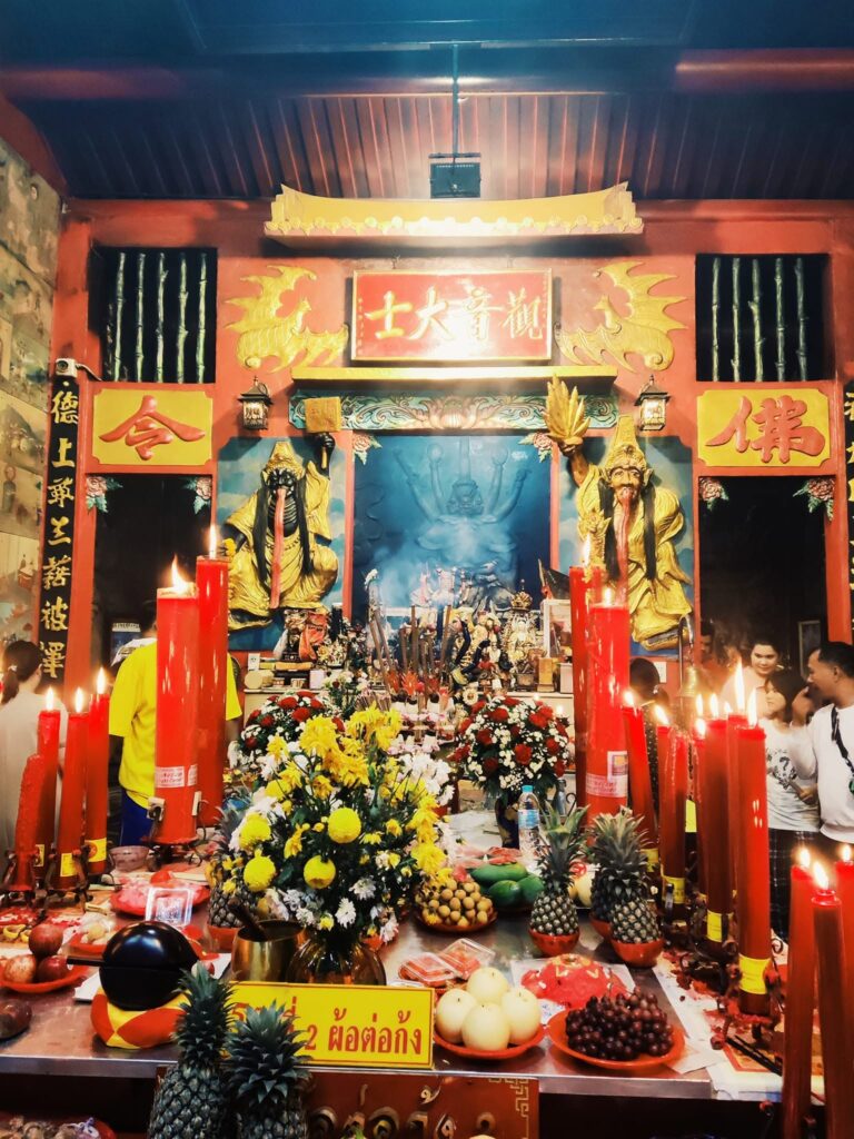 Por Tor Festival shrine offerings and red candles in Phuket Old Town